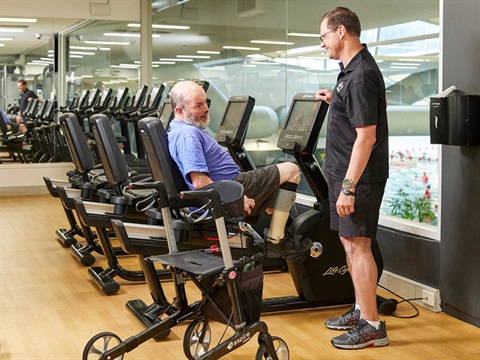 Image of a Personal Trainer and a member of the accessible program in the gym