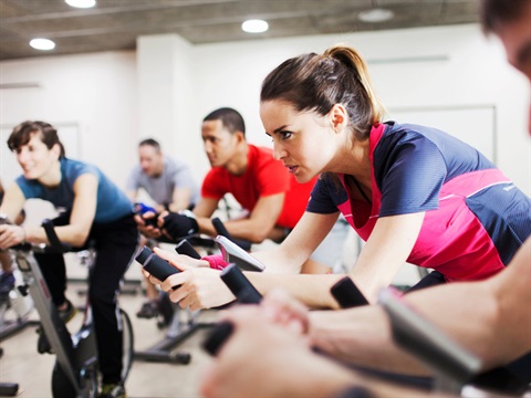 Image of a spin class on cycle bikes with multiple members attending