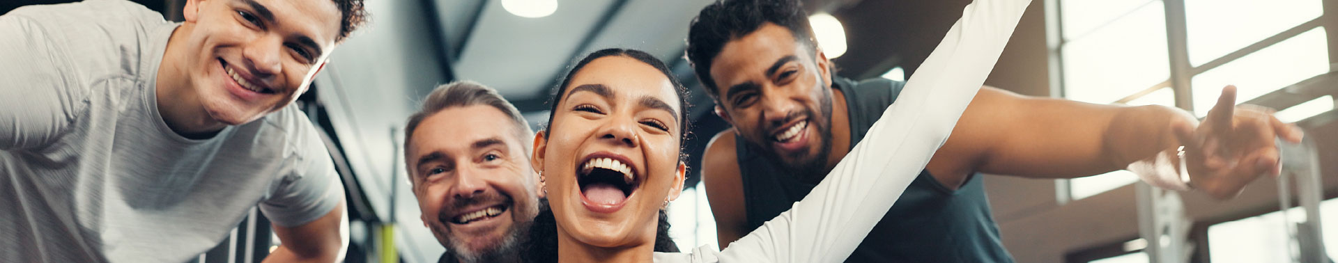 Four people in a gym smiling at the camera