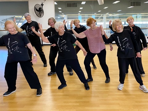 Group of seniors in a studio doing Tai Chi