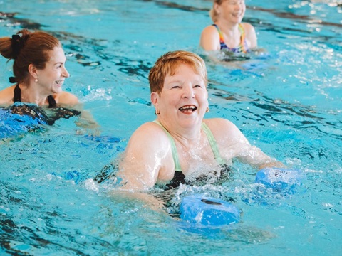 Three women smiling in a swimming pool whilst deep water running
