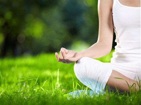 participant sitting with legs crossed on the grass